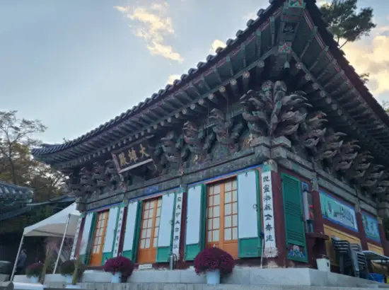 The main hall of Hwagyesa Temple with traditional Korean architecture, located along the Seoul Trail 19 Bukhansan Seongbuk Course, under a soft evening sky.