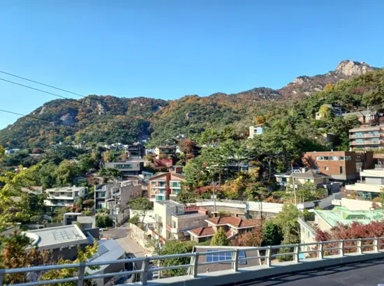 Scenic view of a residential hillside neighborhood with Bukhansan Mountain in the background, along the Seoul Trail 19 Bukhansan Seongbuk Course.