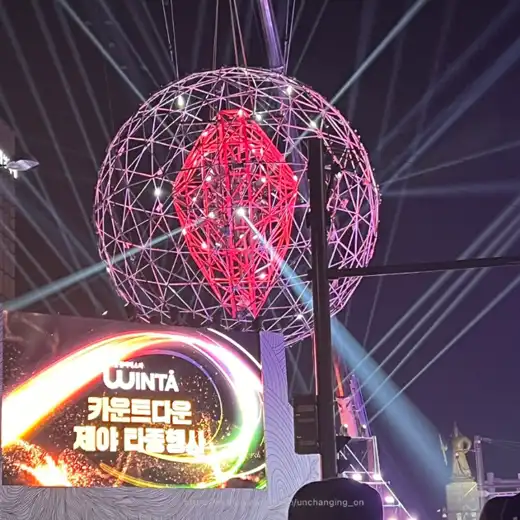 Countdown light show structure displayed during the Seoul Winter Festa, featuring illuminated globe-shaped installation and stage lighting at night.