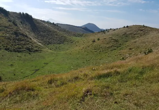 Wide crater basin view of Yongnuni Oreum with gentle slopes and clear Jeju sky.