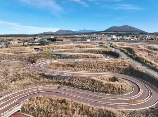 Aerial view of the gravity racing track at 9.81 PARK JEJU with Jeju’s hills in the background