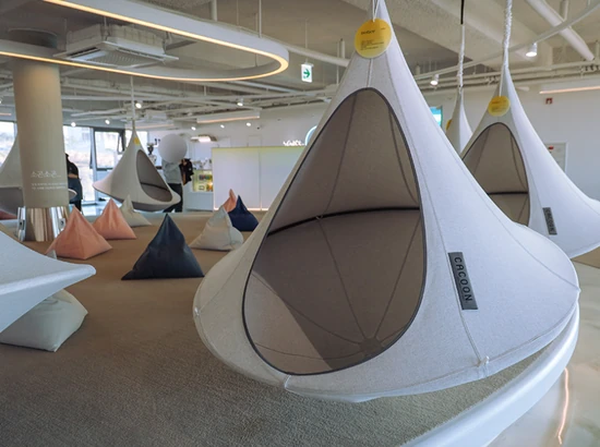 Indoor lounge area with hanging rest pods at 9.81 PARK JEJU, designed for relaxing between activities
