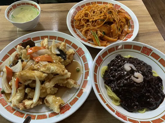 Myeongdong budget restaurants: jjajangmyeon, fried jjamppong, and tangsuyuk set on a wooden table