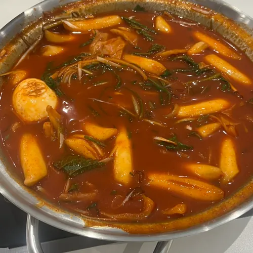 Spicy Korean tteokbokki simmering in red broth with rice cakes and egg