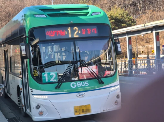 Green Camp Festival 2026 shuttle bus reference image showing Gyeonggi-do city bus 12 (GBUS) at a roadside stop, front view.