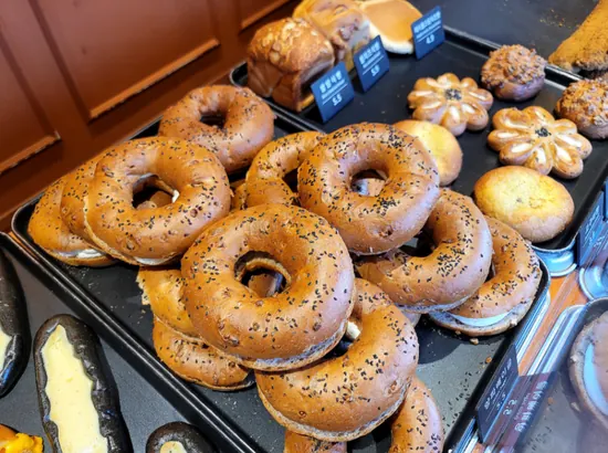 A display of assorted breads at Munhwajebbang Bakery in Jongno, including bagels and other freshly baked items arranged on trays