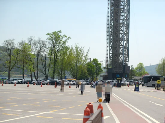 Nami Island parking lot with travelers walking and cars lined up near the entrance area