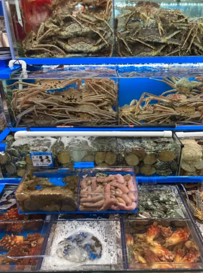 Seafood tank at Noryangjin Fish Market filled with king crabs, shellfish, and assorted fresh seafood on display.