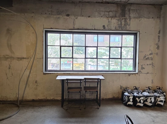 Industrial-style interior at Daelim Changgo in Seongsu with a large window, concrete wall, and small table seating