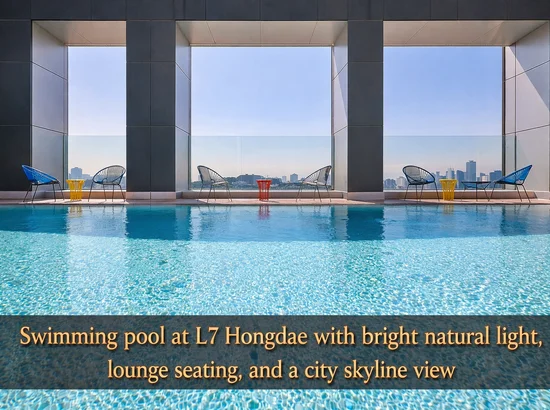 Swimming pool at L7 Hongdae with lounge chairs, tall open windows, and a city view